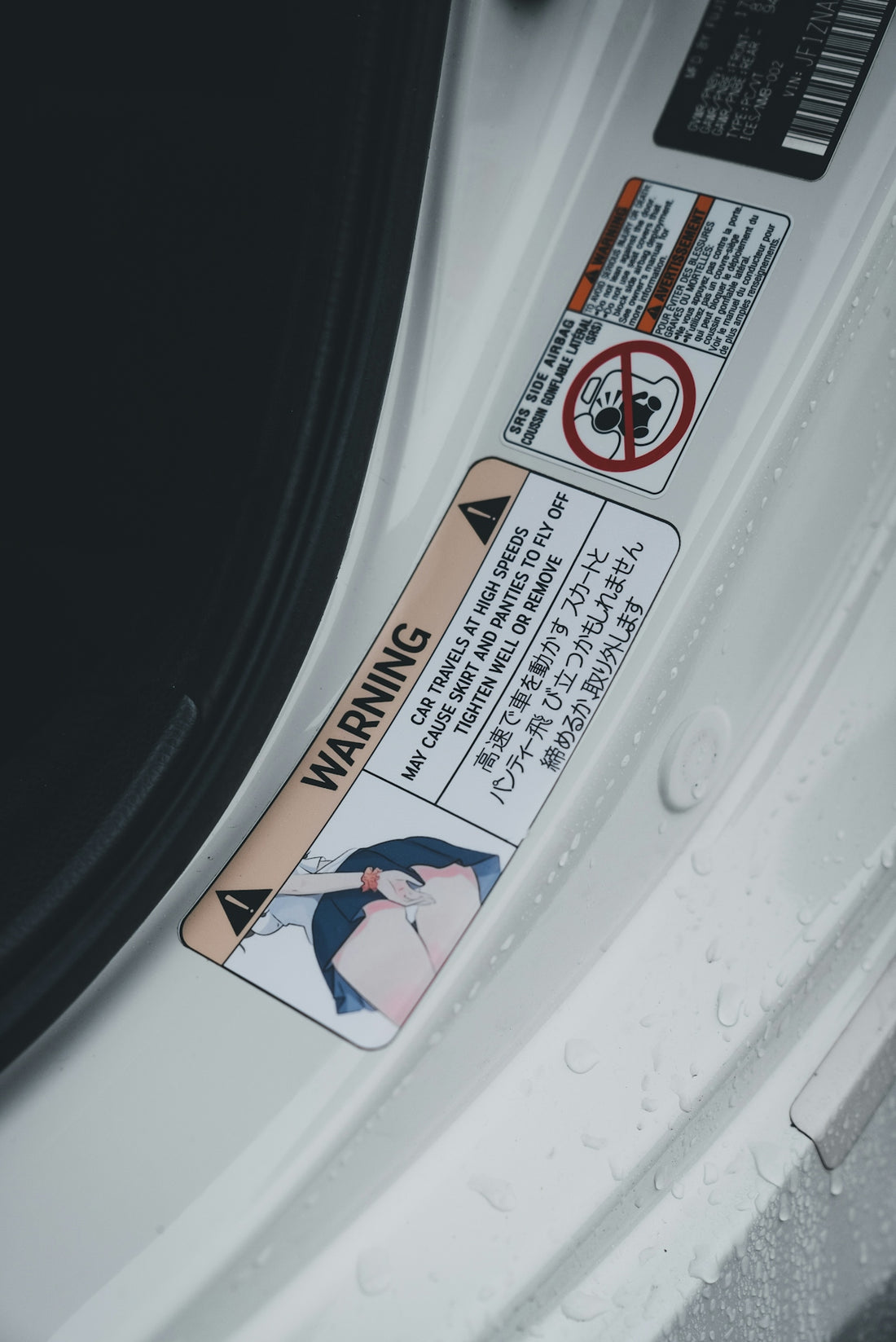 A car's door has warning stickers in japanese.