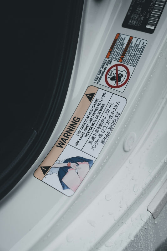 A car's door has warning stickers in japanese.