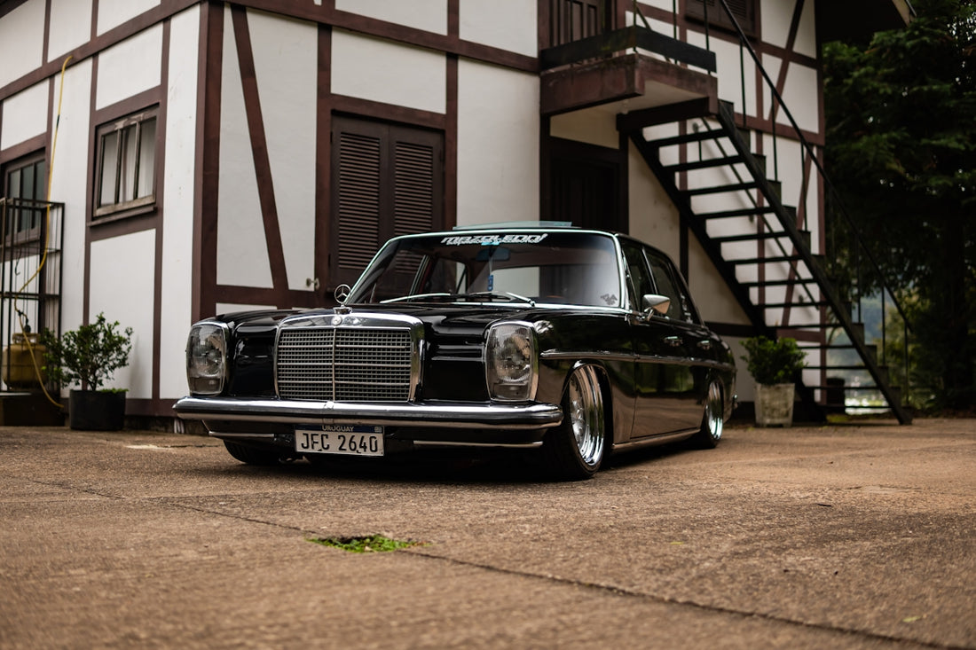 Classic black mercedes-benz sedan parked outside building.