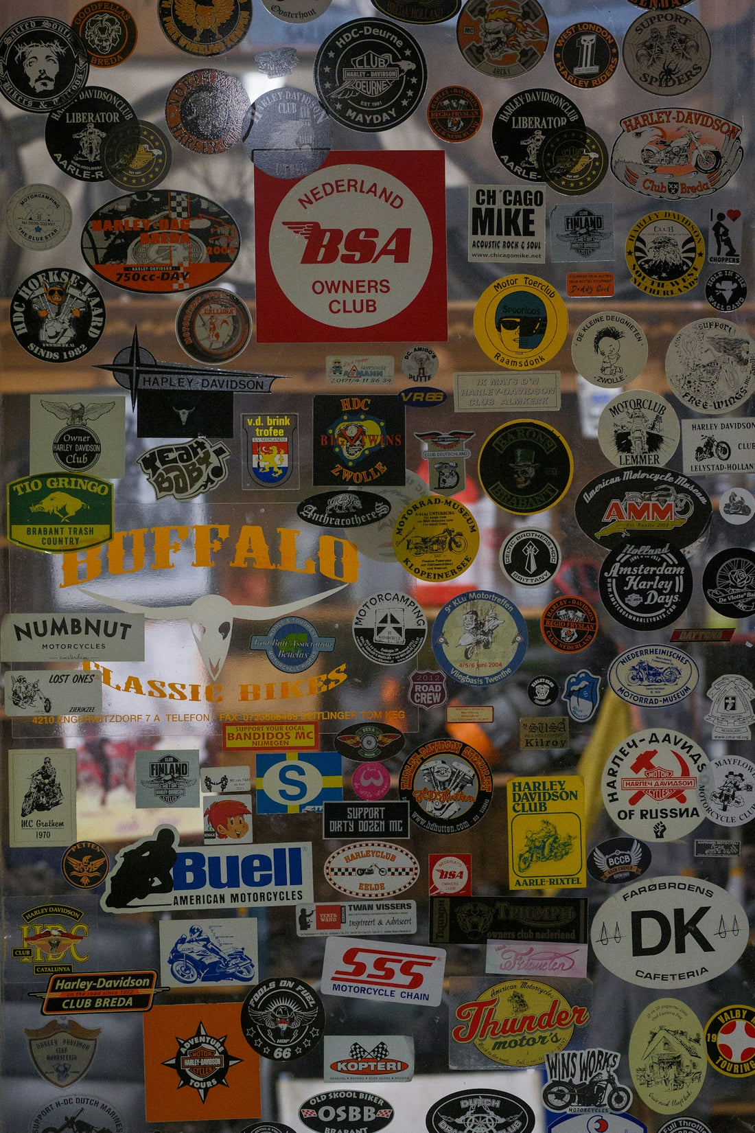 Collection of vintage motorcycle club stickers on a surface.