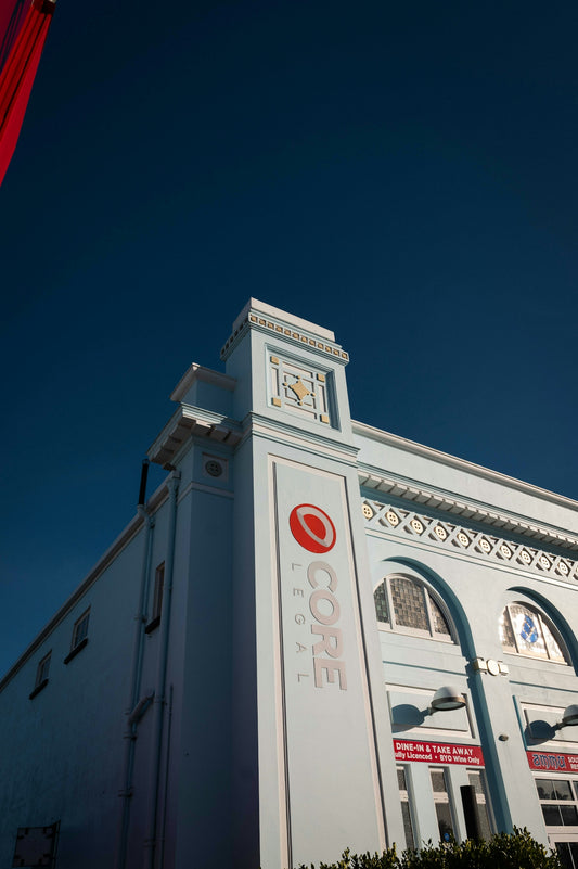Pale blue building with arched windows against clear sky
