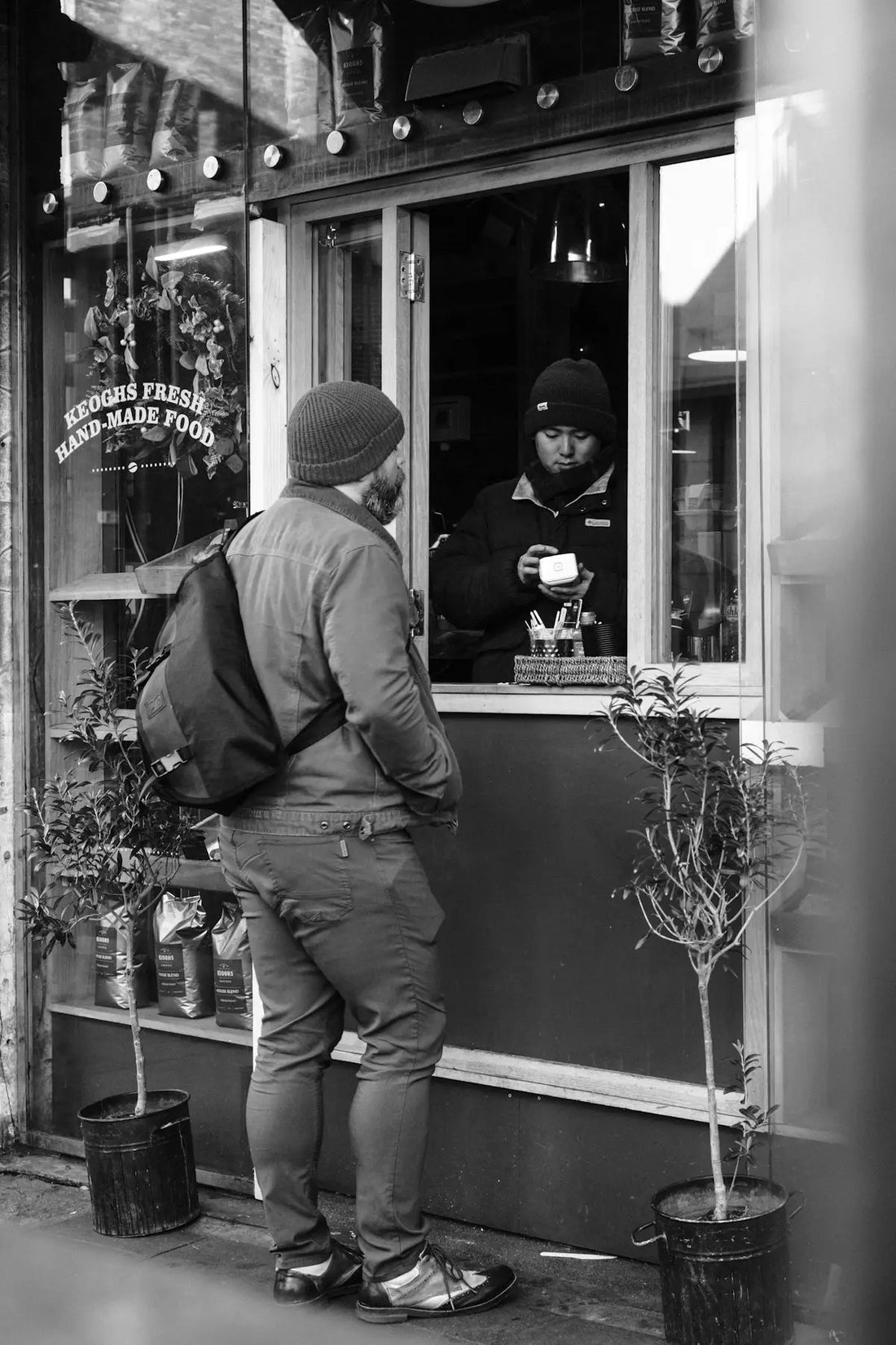 Man ordering coffee from a street vendor
