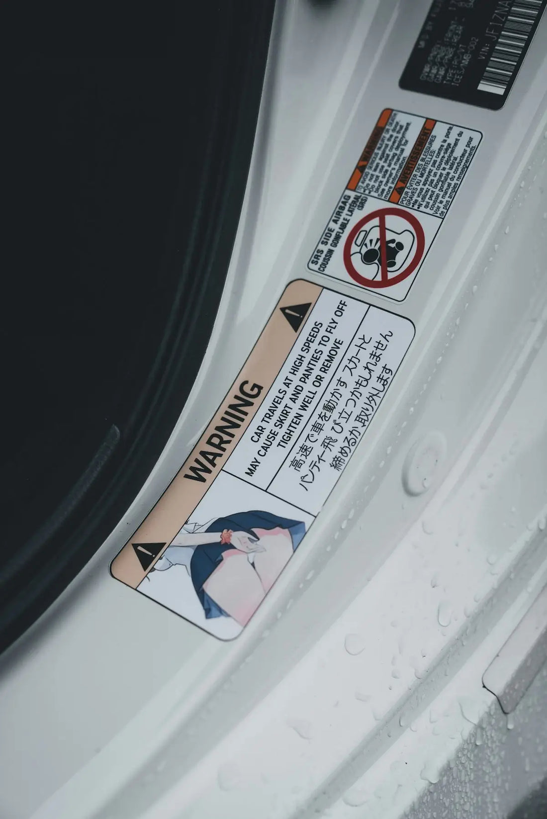 A car's door has warning stickers in japanese.