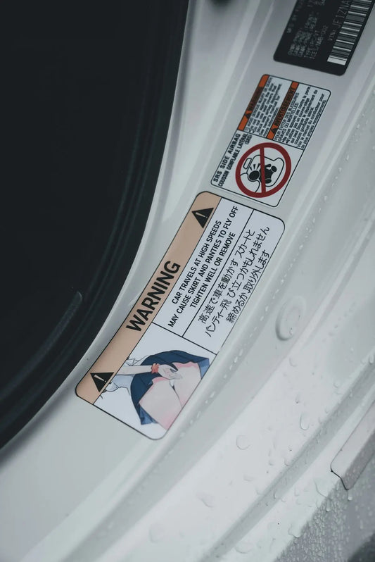 A car's door has warning stickers in japanese.
