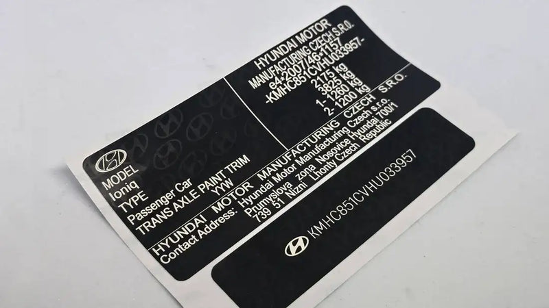 Black hyundai vehicle identification label with white text and logo, displaying model information for an ioniq.