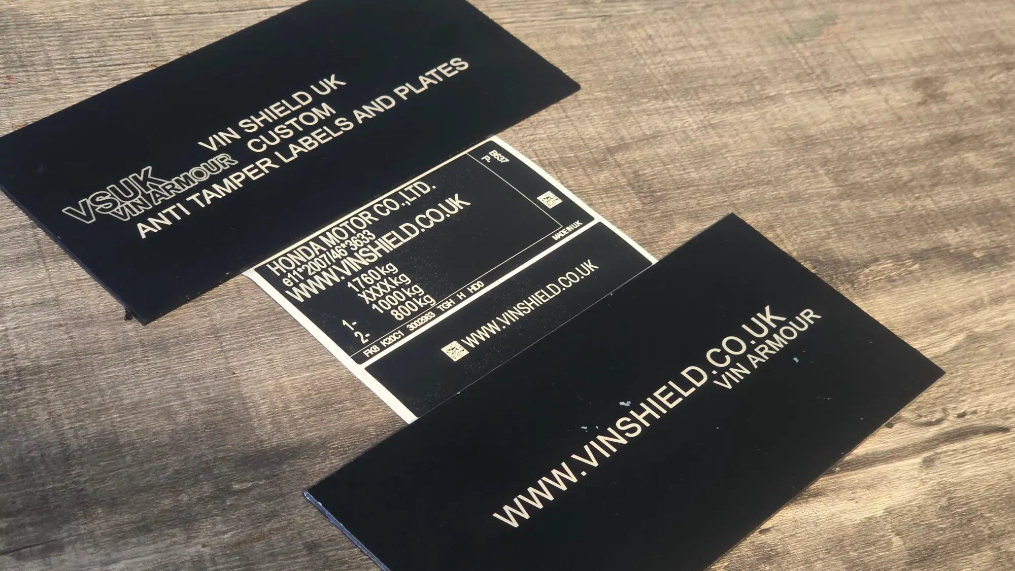 Black rectangular anti-tamper labels with white text and a central label featuring honda motor co.