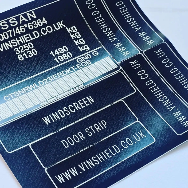 Dark blue vinyl sticker sheet with white text and barcode labels for nissan windscreen, door strip, and other vehicle parts.