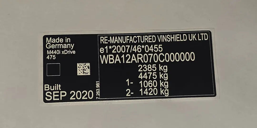 Black and white VIN plates from VINSHIELD UK showing chassis numbers and weight details made in Germany